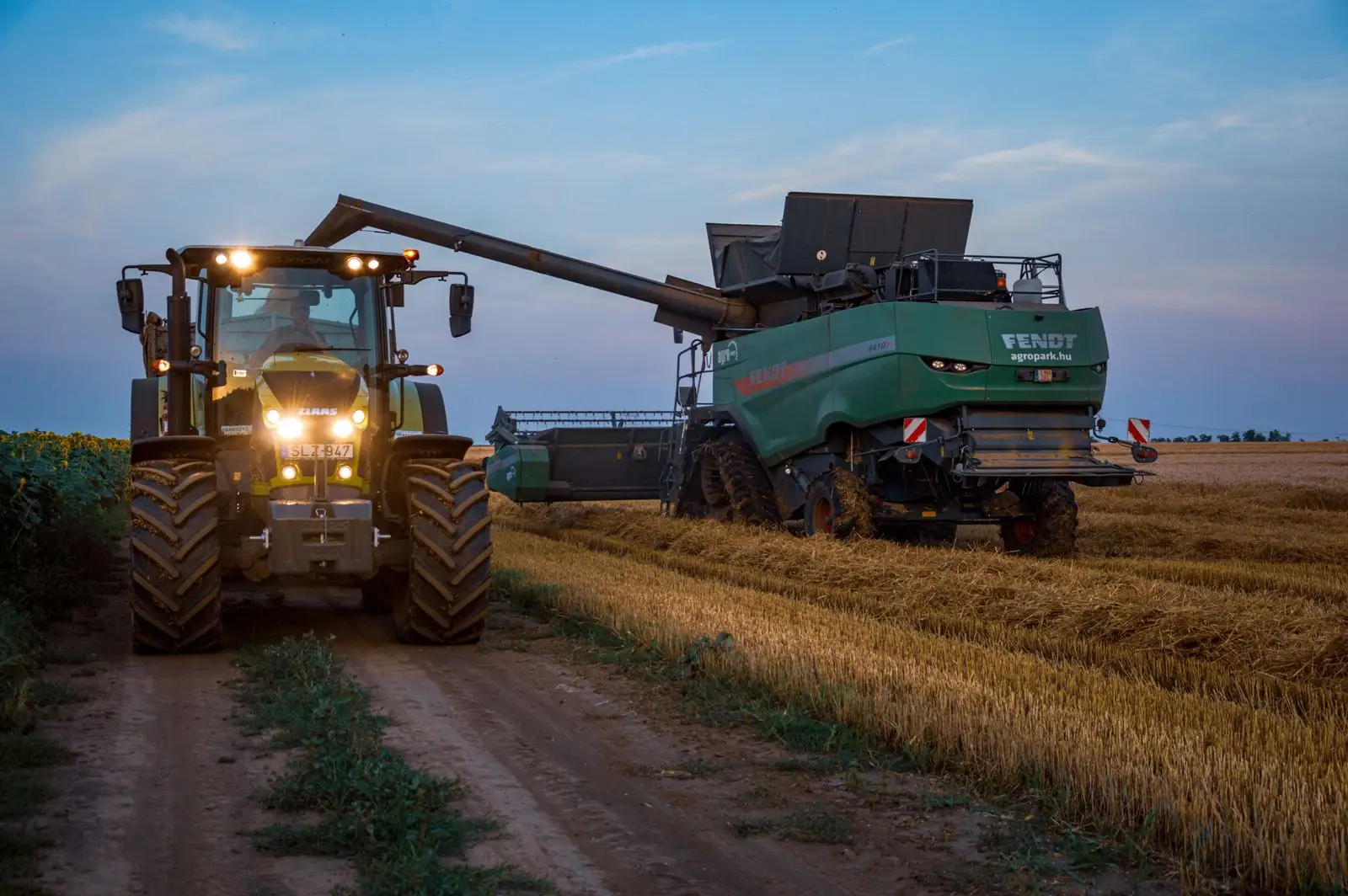 Modern agricultural tractors and harvesting equipment staged in an industrial manufacturing facility