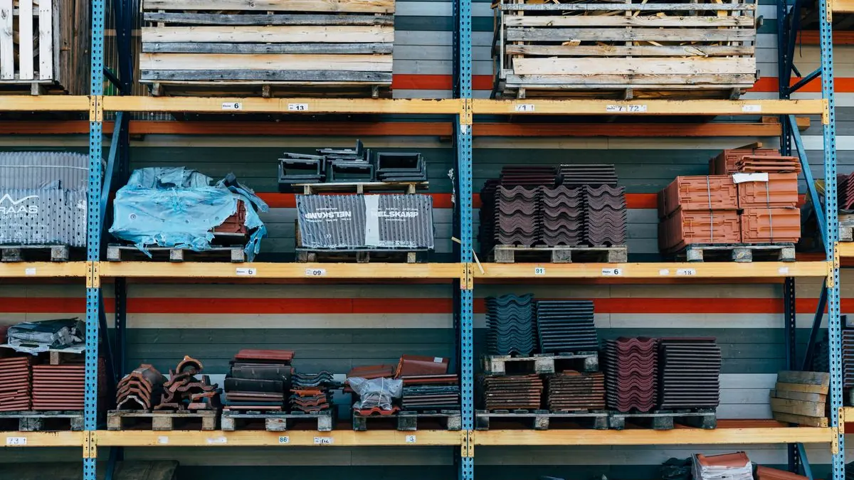 Construction materials and structural steel components neatly staged in a modern manufacturing warehouse