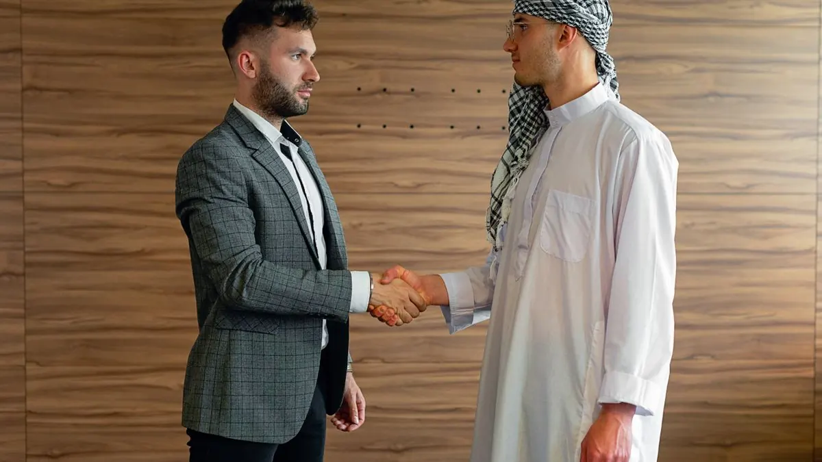 Two businesspeople shaking hands, symbolizing a sourcing agent partnership